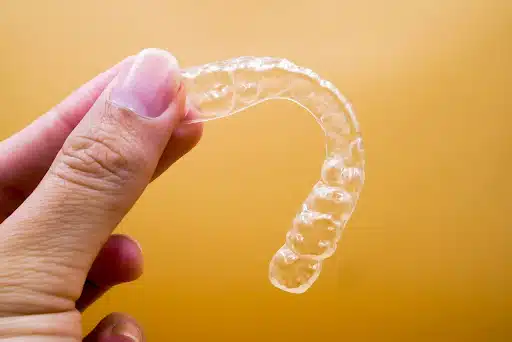 Clear Aligner Tray Held By Hand Showing Invisalign Treatment Time Progress